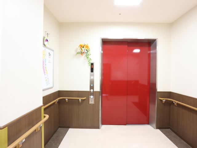 赤いエレベーターの扉 エレベーター 明るい色調の壁と調和する、赤いエレベーターが設置されています。