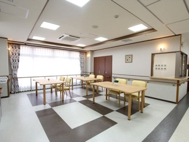 多目的室の内装 ホール 広々とした多目的室は、落ち着いたデザインの椅子やテーブルが整えられ、明るい自然光が差し込んでいます。