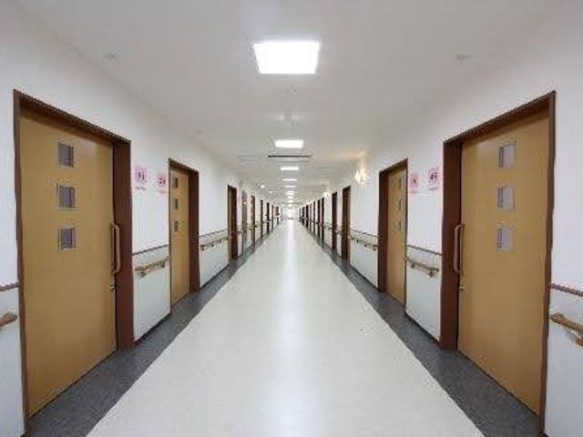 明るい廊下 廊下   左右に居室の扉が並ぶ、見通しのよい明るい廊下です。手すりがあり、移動しやすそうなつくりです。