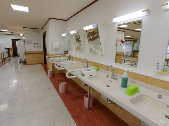 洗面所の明るい空間 洗面台 手すり付きの洗面台で、安全と利便性を兼ね備えています。清潔感あふれる空間で、快適にお過ごしいただけます。