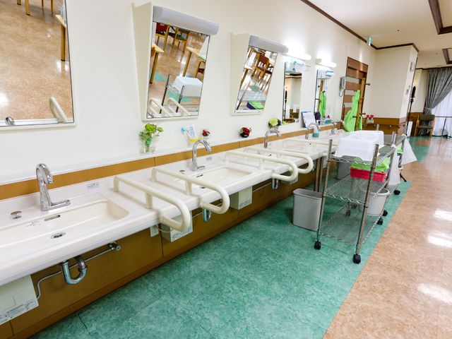 洗面台が並ぶ清潔な空間 洗面台 手すり付き洗面台の配置が安全で使いやすい環境を実現しています。