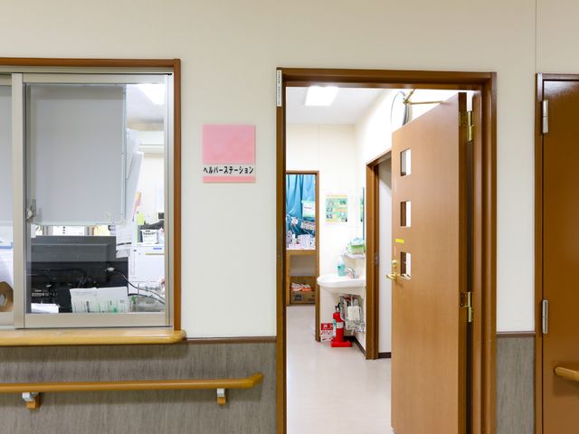 廊下と看護ステーション ヘルパーステーション 清潔感のある通路を備え、手すりも設置されており安全に配慮されています。
