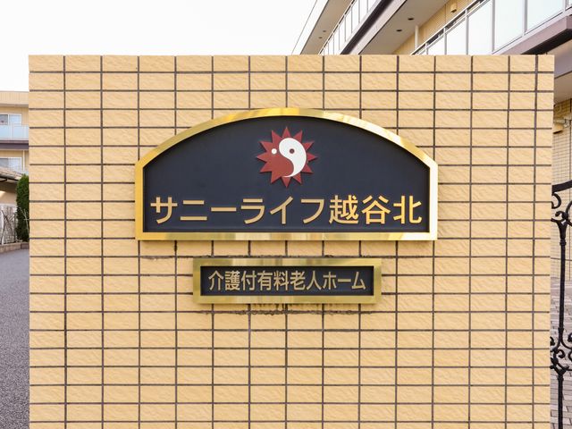 施設のシンボル看板 看板 迎える入口には、落ち着いた色合いの看板があります。品のあるデザインが印象的です。