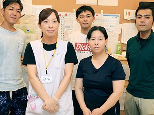 スタッフが並ぶ室内  