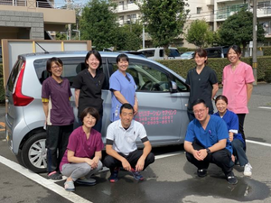 送迎車の前に立つスタッフ  
