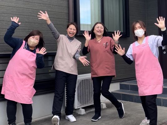 笑顔で手を振る職員の外観  