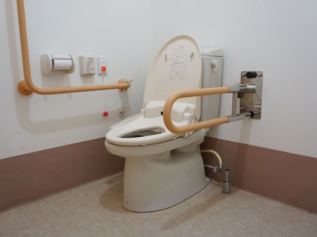 バリアフリートイレの設備 トイレ 手すりが設置された広々とした快適なトイレです。全ての方が安心してお使いいただける環境が整っています。