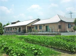 緑に囲まれた一階建て建物