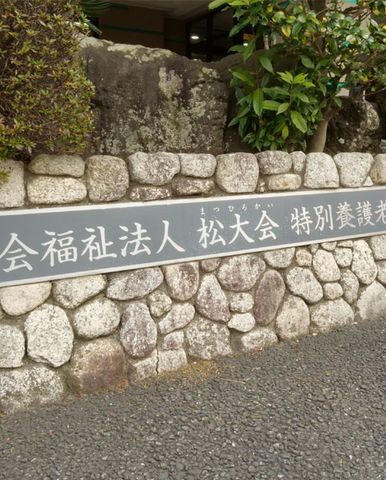 表示がある石の壁 看板 落ち着いた石の壁が存在感を示し、施設名がはっきりと記された看板です。