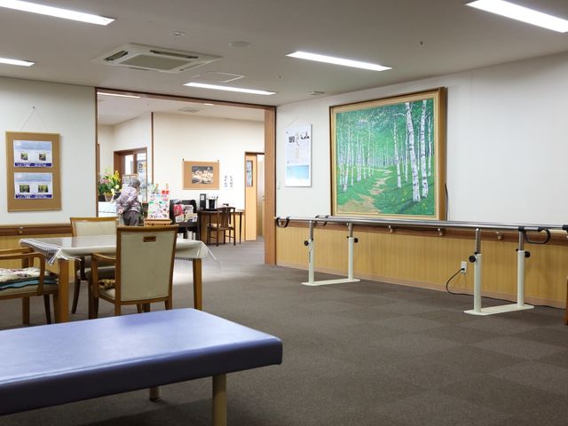 共有エリアの景観 共有スペース 広々としたラウンジには、明るく安らげる木目調のデザインが取り入れられ、ゆったりとしたソファが配置されています。日々の憩いの場としての機能を備え、利用者がリラックスして過ごす姿がうかがえます。