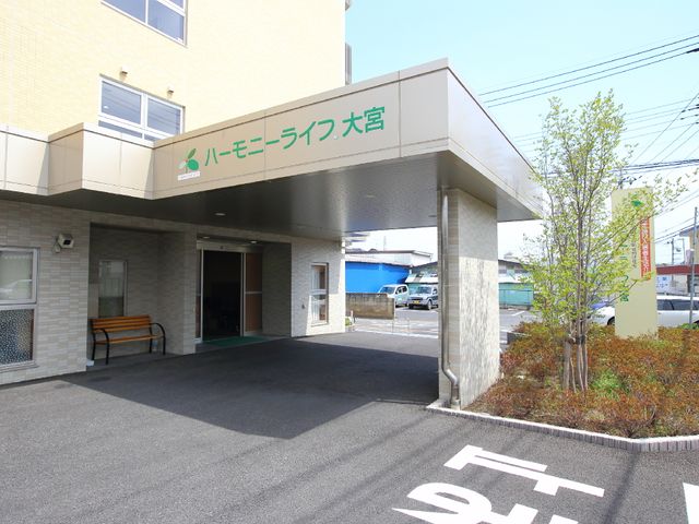 ハートモライフ入口 玄関部分外観 温かみのあるデザインのエントランスは、訪れる人々を優しく迎え入れます。ベンチが置かれ、一息つきながらの交流も楽しめます。