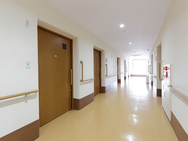明るい廊下の様子 明るい色調の廊下 手すりが設置された清潔で広々とした廊下は、ご利用者の移動を安全にサポートします。