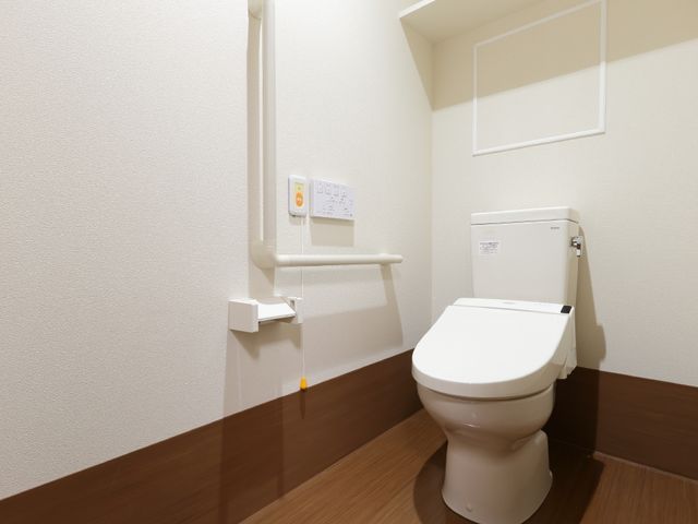バリアフリートイレ 呼び出しボタンのついたトイレ 安全に配慮された手すり付きの清潔なトイレです。利用者の方々の快適な日常生活を支援しています。