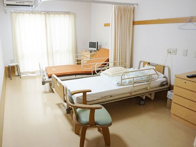 ベッドと椅子の居室 居室 明るい空間に快適なベッドと椅子が配置された部屋です。自然光が優しく差し込む設計になっています。
