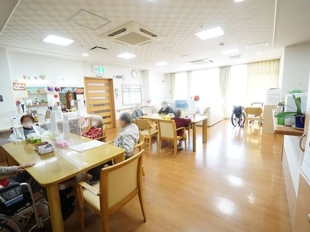 利用者の憩いの場 共有スペース 広々として明るい空間で、利用者がゆったりと過ごす姿が見受けられます。共に時間を過ごす場として、日々の暮らしに彩りを添えます。