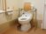 サムネイル 車椅子対応のトイレである。I型や背もたれ付きの手すりが壁や便器に設置されている。洗面台が備わっている。
