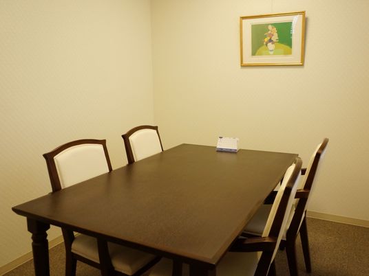 施設には、相談室が設けられている。４人掛けテーブルが配置されており、卓上カレンダーが上に置かれている。