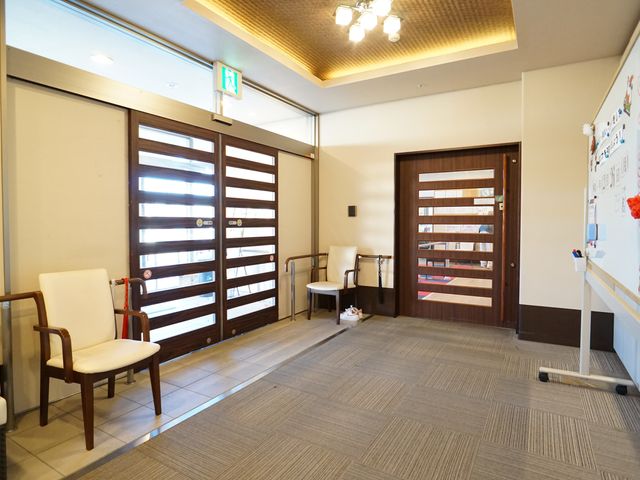 玄関エリアの明るい空間 玄関 広々としたエントランスは椅子が配され、待合や交流の場としてもご利用いただけます。壁面には掲示板があり情報共有も行われています。