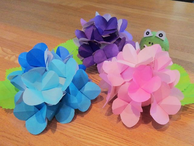 色とりどりの花の飾り 掲示物 カラフルな花の飾りがテーブルに飾られており、和やかな雰囲気を演出しています。