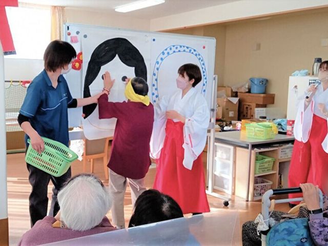 楽しげな集会の様子 多目的室 明るい多目的スペースでは、楽しげなアクティビティが行われています。職員と利用者が笑顔で活動しています。