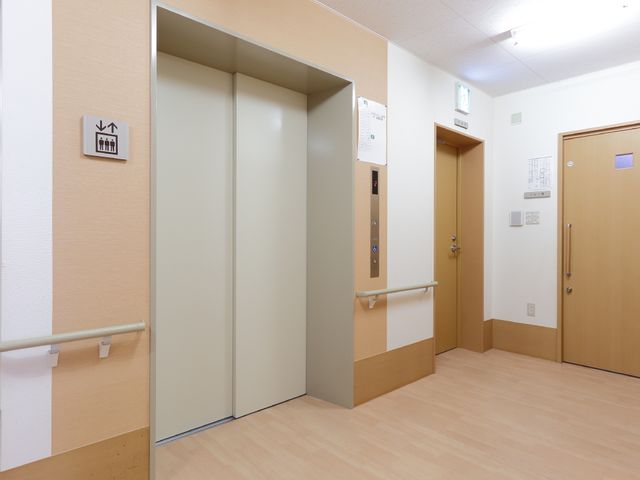 清潔な廊下のエレベーター エレベーターホール 広々とした通路に面したエレベーターは、バリアフリー設計で安全性にも配慮された設備です。手すりが整備されており、快適な移動が支援されています。