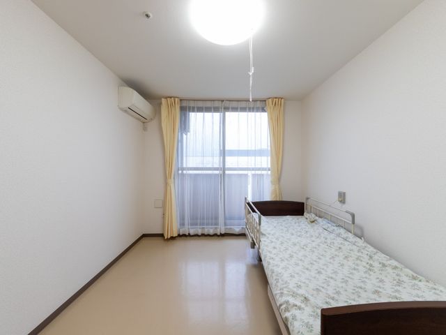 明るい居室のベッド 居室 窓から光が入る、すっきりした居室です。ベッドが配置されており、落ち着いて過ごしやすい空間です。