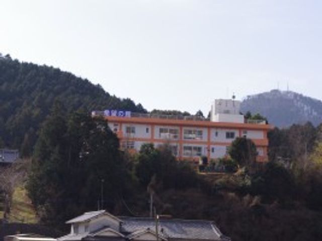 山に囲まれた建物の外観 外観   自然に囲まれた立地で、落ち着いた雰囲気の建物です。就業先として、静かな環境を重視する方に向いています。