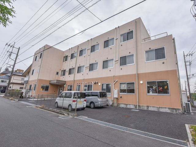 多階建ての施設外観 外観 ゆったりとした駐車スペースがある、清潔感のある建物です。窓からは明るく柔らかい光が差し込んでいる様子が伺えます。