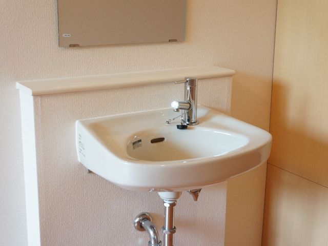 壁に固定された手洗い器 洗面台 手洗い場は清潔感があり、使いやすいデザインで、快適な環境を提供しています。アクセスが容易で、日々の衛生管理に役立つ設計になっています。