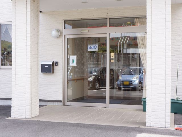 明るい施設のエントランス 玄関  明るく開放的なエントランスは、ご家族や来訪者を温かく迎え入れます。アクセスに便利な立地です。