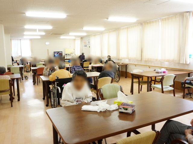 共有リビングの様子 食堂  様々な催しも開催されるダイニングスペースです。広々と利用者が会話を楽しんでおり、温かな雰囲気が感じられます。