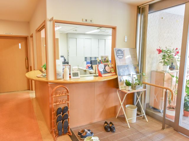 暖かみのある受付カウンター 受付窓口 丸みを帯びたデザインの受付カウンターです。訪れる方々へのおもてなしの心が感じられる快適な空間が提供されています。