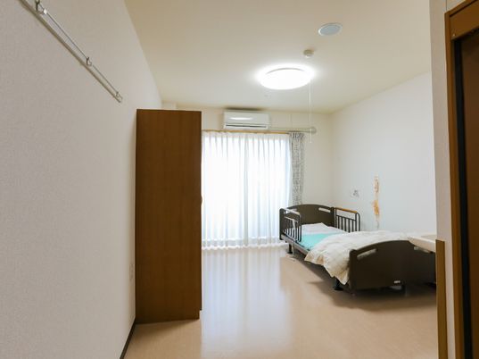 明るい室内とベッドのある居室