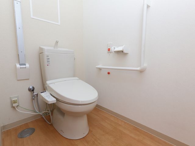 バリアフリートイレ設備 居室トイレ サポート手すり付きのトイレで、安心してご利用いただける設計になっています。機能的で清潔感のある空間を提供しております。