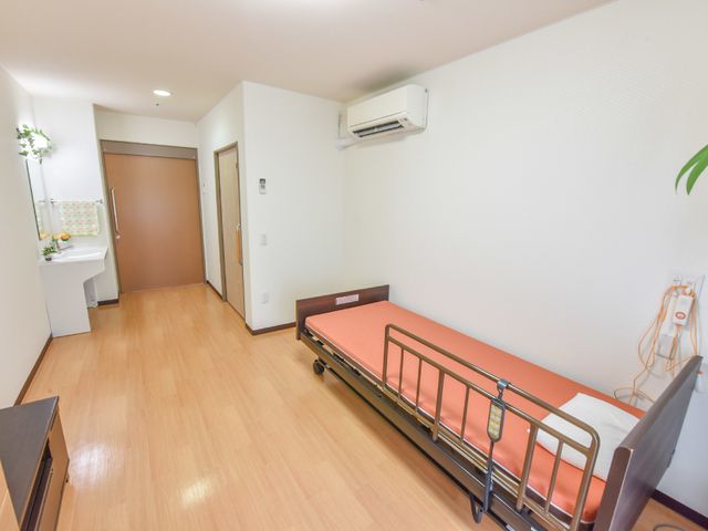 居室の清潔な空間 居室 広々として清潔感があり、落ち着いた色合いの居室です。日々の生活に必要な設備が整っており、快適にお過ごしいただけます。