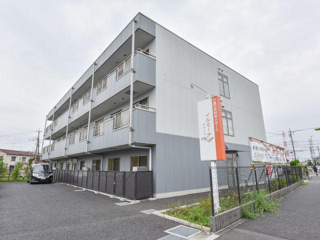 灰色の建物とオレンジ看板 看板 新しい施設の外観は、すっきりとしたデザインで安心感を与えます。オレンジの看板が目印で、訪れやすい雰囲気です。