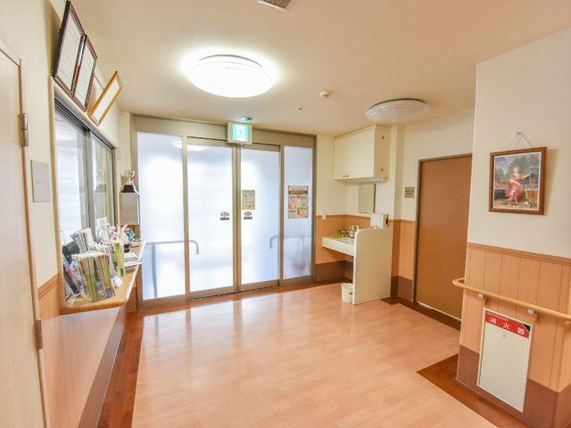 明るいエントランスの様子 照明 受付は清潔感があり、床のバリアフリー設計により安全です。来訪者の方へ心地よい印象を与えるエントランスがこちらです。