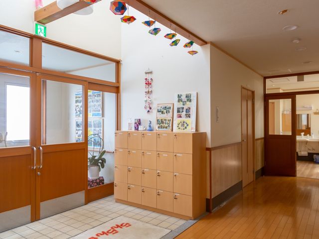 廊下とロビーの明るい空間 エントランス 暖かな光が差し込む廊下は、清潔感があり落ち着いた色合いで整えられています。利用者の方々が気持ちよく過ごせる環境です。