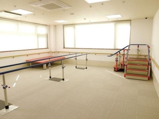 機能訓練用具のある室内 機能訓練室 明るく広々とした空間で、バランスの鍛錬や階段昇降の練習が行えます。利用者のリハビリを支援する設備が整っております。