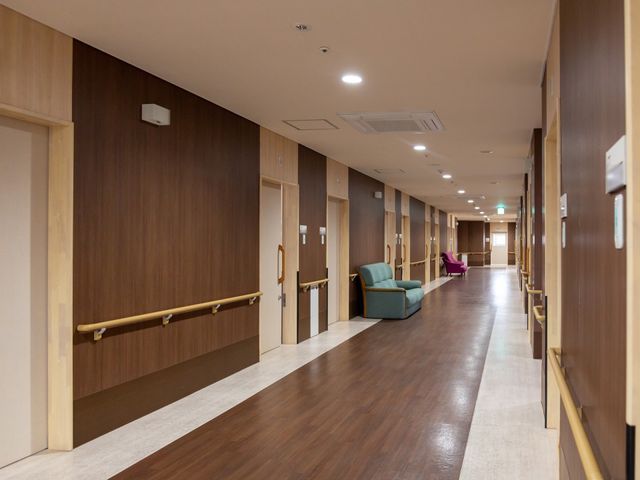 温かみのある廊下 通路 手すり付きの広々とした廊下が心地よい環境を提供しています。安全に配慮されたデザインは就業を検討される方にも安心です。