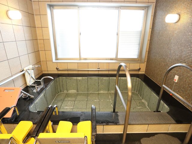 バリアフリー設計の浴室 浴室 手すりや椅子が配備された使いやすい浴室です。利用者の安全と快適さを考えた設計になっています。