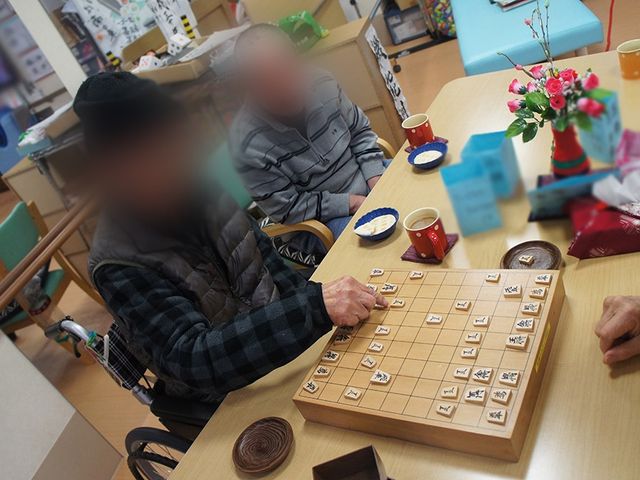 将棋を楽しむ人々の様子テーブル リビング リビングでは、皆さんが将棋を楽しんでいます。和やかな空間で交流が深まります。