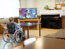 車椅子の人とピアノのあるラウンジ