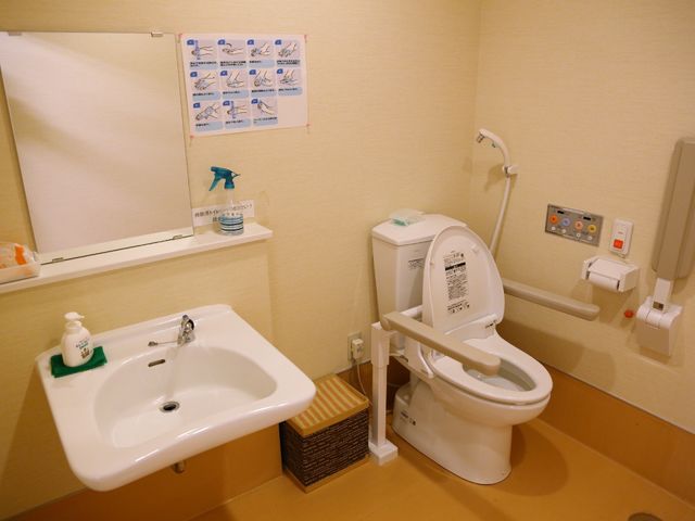 清潔感あるトイレスペース トイレ 壁には手洗いの手順が示されており、使いやすい高さの洗面台が設置されています。バリアフリーの配慮も行き届く仕様となっており、安心してご利用いただけます。