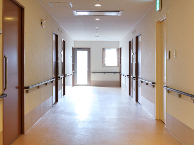 清潔な廊下の様子 廊下 広々とした廊下は明るく清潔感があり、壁側の手すりが歩行のサポートをしています。全体の雰囲気は日々の生活に落ち着きと安心を提供しています。