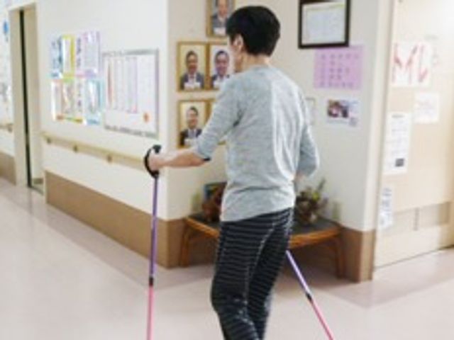 廊下を歩く人 レクリエーション 明るく清潔感のある廊下で、リハビリを行う姿が見受けられます。スタッフのサポートも整っており、心強い環境です。