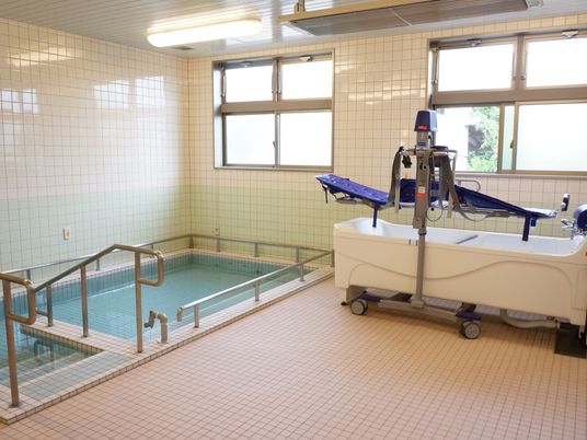 広々した浴室である。窓側には自力での入浴が困難な入居者様のために、介護専用の入浴機器を備え付けている。