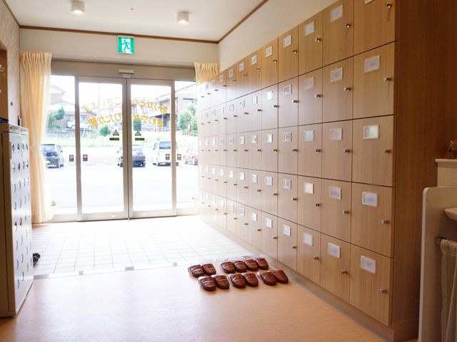 エントランスの靴箱とスリッパ 玄関 明るく開放的なエントランスでは、整然とした靴箱と訪れる方へのスリッパが用意されており、歓迎の気持ちが伝わります。
