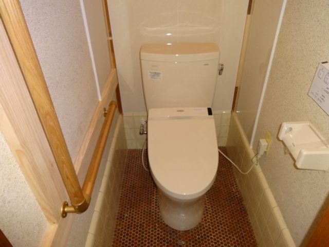手すり付きのトイレ トイレ 手すりが設置された安全設計のトイレです。狭いスペースでも安心して使用できます。