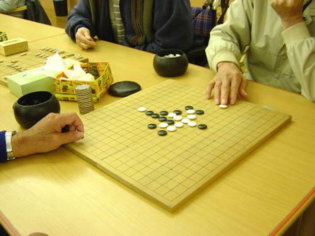 楽しげな囲碁の時間 ラウンジ 手元に集中する方々が囲碁を楽しんでいる和やかな共用スペースです。脳トレにも最適な場所となっています。